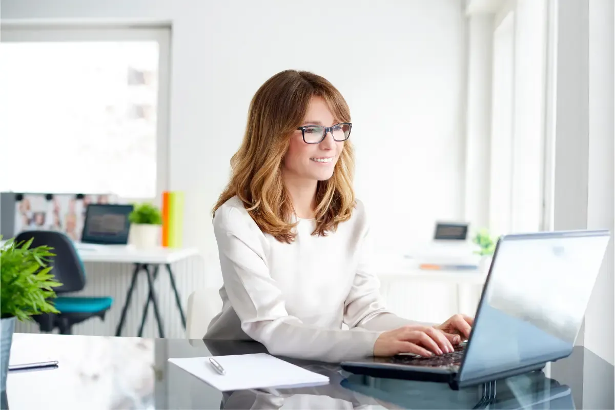 best-registered-agent-services-img.webp Professional businesswoman working on laptop in modern office managing registered agent services and business compliance requirements.