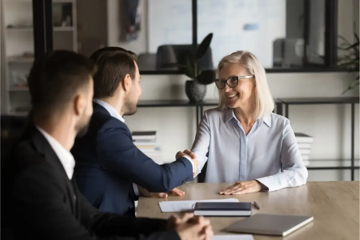 Boomer business owner meeting with younger buyers to discuss selling a small business.