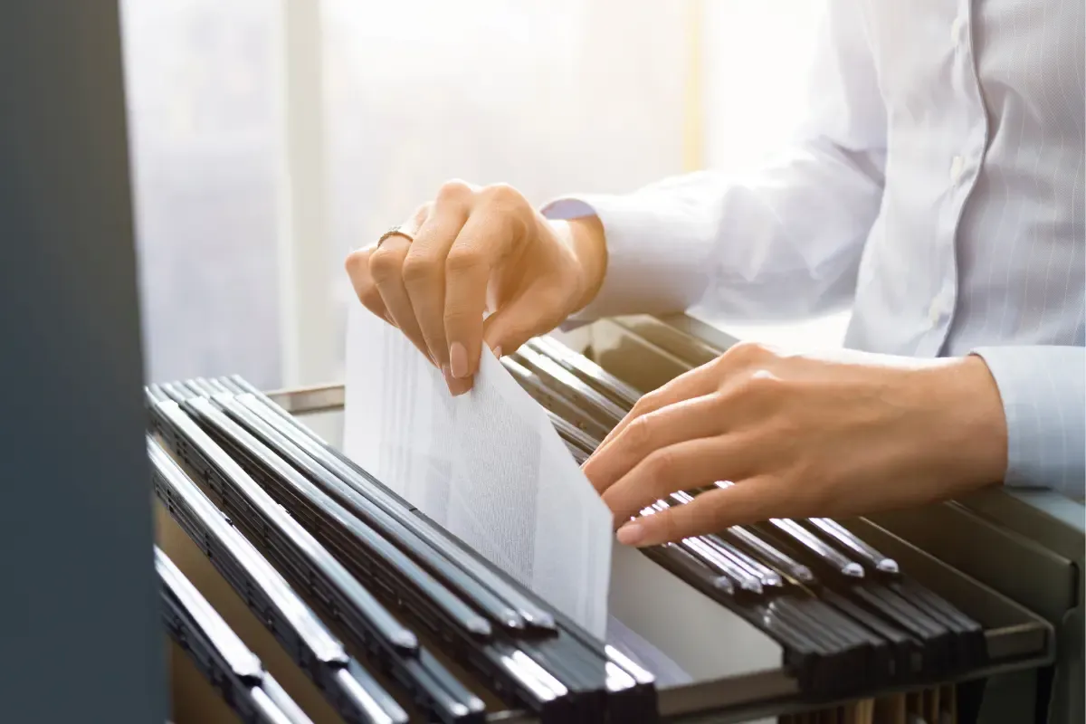 Business owner organizing and retaining business records following record keeping requirements for closed businesses and IRS record retention guidelines.