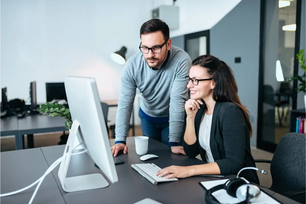 Business team performing UCC lien lookup and due diligence search on a computer to verify secured transaction records before a commercial agreement